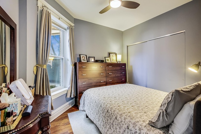 bedroom with hardwood / wood-style floors, a closet, and ceiling fan