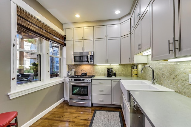 kitchen featuring backsplash, sink, stainless steel appliances, and dark hardwood / wood-style floors