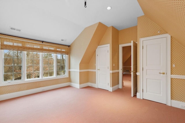 additional living space with vaulted ceiling and carpet flooring