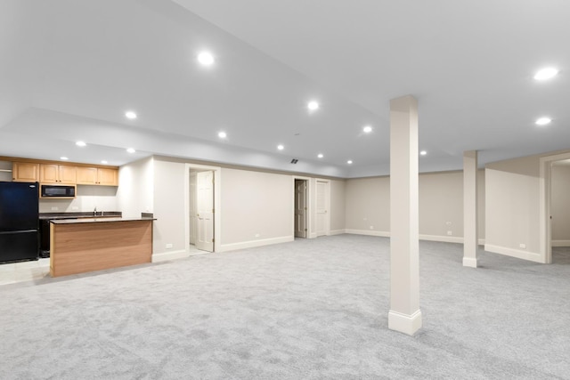 basement with black refrigerator and light carpet