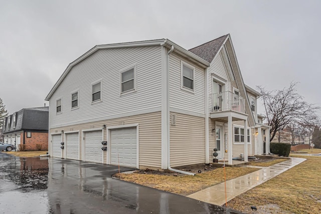 view of side of property with a balcony and a garage