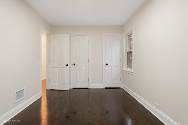 unfurnished bedroom featuring dark hardwood / wood-style flooring