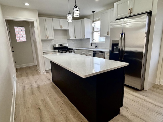 kitchen featuring white cabinetry, appliances with stainless steel finishes, a center island, and sink