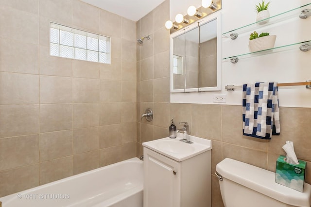 full bathroom featuring vanity, tiled shower / bath combo, tile walls, and toilet