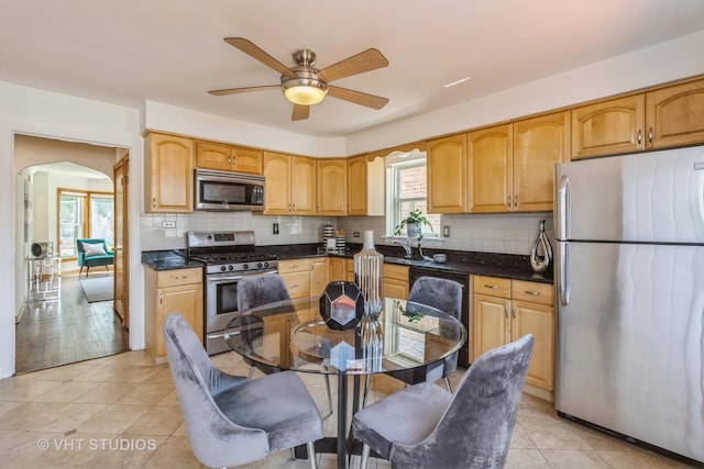 kitchen with tasteful backsplash, ceiling fan, stainless steel appliances, and light tile patterned flooring