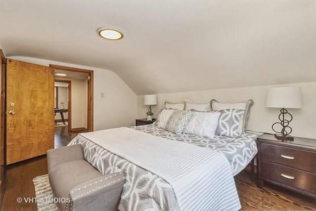 bedroom with dark wood-type flooring and lofted ceiling