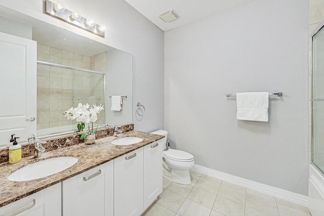 full bathroom featuring tile patterned flooring, vanity, bath / shower combo with glass door, and toilet