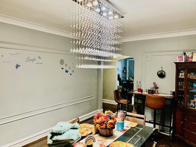 dining space with ornamental molding and dark hardwood / wood-style floors