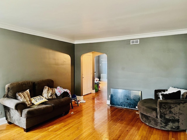 living room with wood-type flooring and ornamental molding