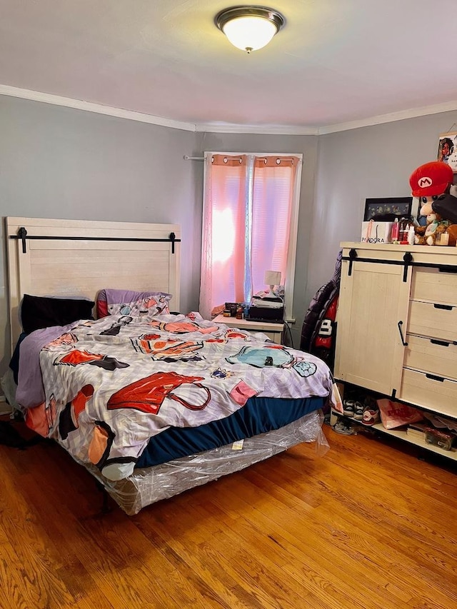 bedroom featuring crown molding and light hardwood / wood-style floors