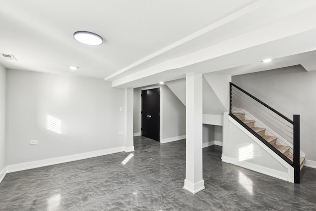 finished basement with baseboards, stairs, and visible vents