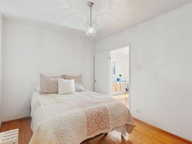 bedroom featuring hardwood / wood-style flooring and ensuite bath