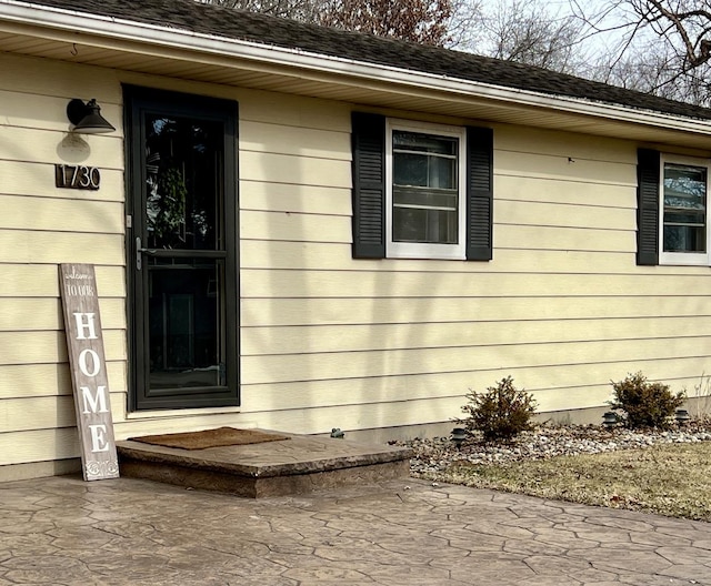 view of exterior entry with a patio