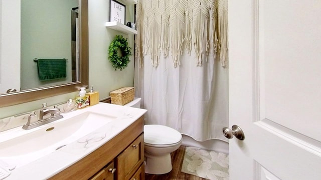 bathroom featuring vanity, toilet, and walk in shower