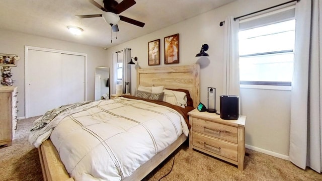 bedroom featuring ceiling fan, a closet, and light carpet