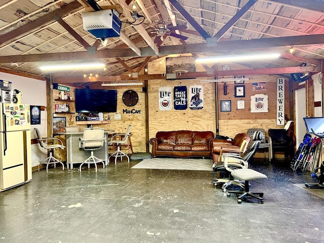 basement featuring white refrigerator and ceiling fan