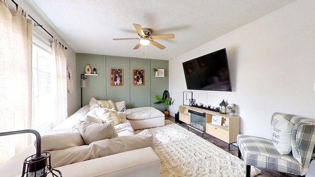 living room featuring dark hardwood / wood-style floors, a textured ceiling, and ceiling fan