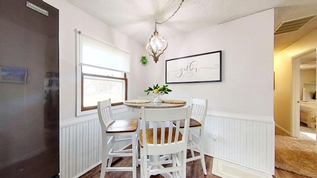 dining space with hardwood / wood-style floors and a chandelier