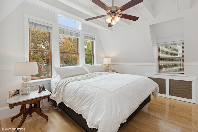 bedroom with multiple windows, radiator, and light hardwood / wood-style flooring