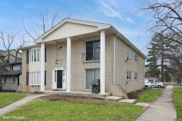 neoclassical home featuring a front yard