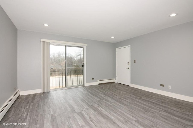 spare room featuring a baseboard radiator and dark wood-type flooring