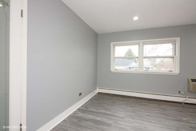 spare room with a baseboard heating unit and wood-type flooring