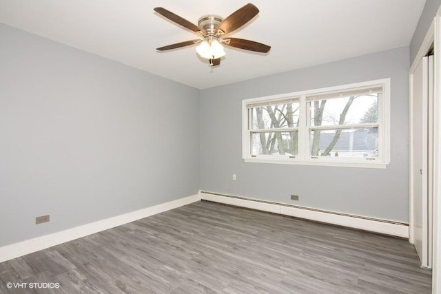 unfurnished room featuring dark hardwood / wood-style flooring, ceiling fan, and baseboard heating