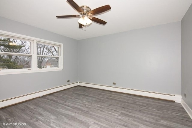 spare room featuring a baseboard heating unit, dark hardwood / wood-style floors, and ceiling fan