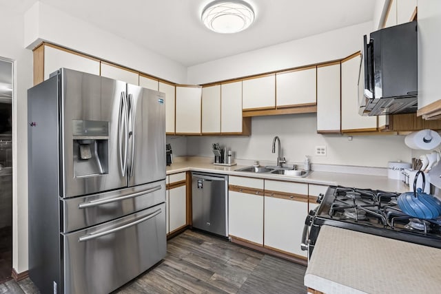 kitchen with sink, dark wood-type flooring, stainless steel appliances, and white cabinets