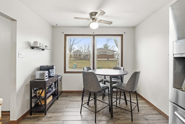 dining area with dark wood-type flooring and ceiling fan