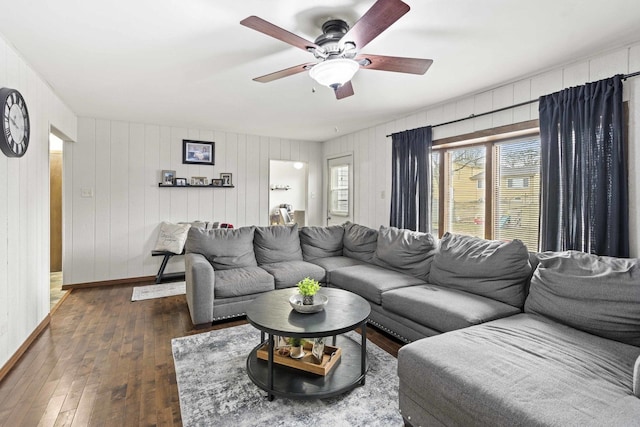 living room featuring dark wood-type flooring and ceiling fan