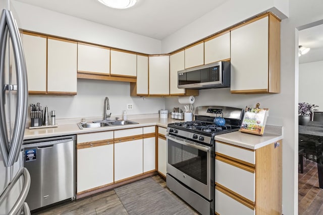 kitchen with dark wood-type flooring, stainless steel appliances, sink, and white cabinets