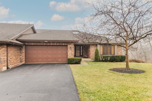 ranch-style home featuring a garage and a front lawn