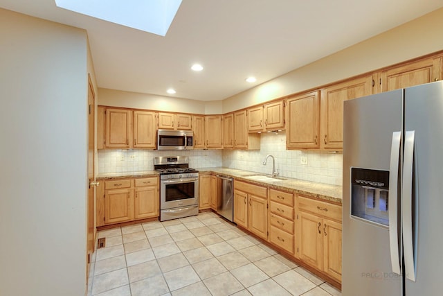 kitchen with backsplash, appliances with stainless steel finishes, sink, and light brown cabinets