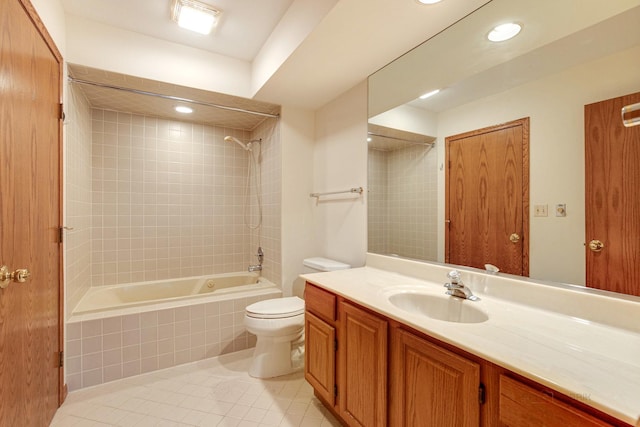 full bathroom featuring tiled shower / bath, vanity, tile patterned floors, and toilet