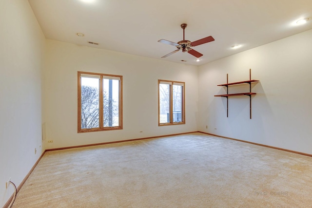 empty room with ceiling fan and light carpet