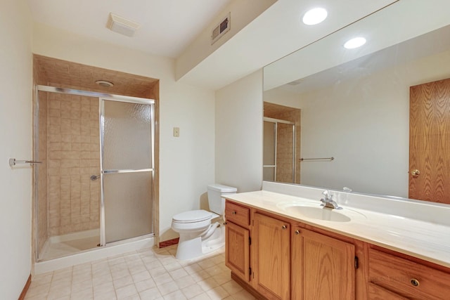 bathroom featuring tile patterned floors, vanity, toilet, and a shower with shower door