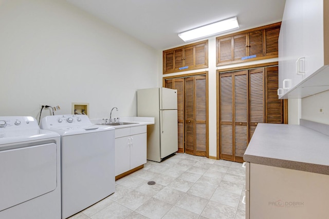 laundry room with cabinets, washer and dryer, and sink