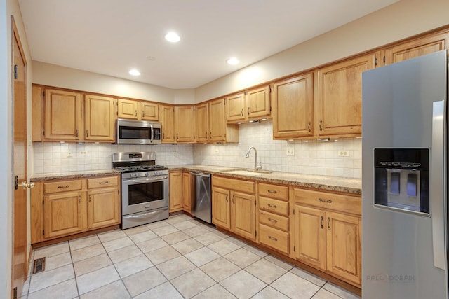 kitchen with tasteful backsplash, sink, light stone counters, and stainless steel appliances