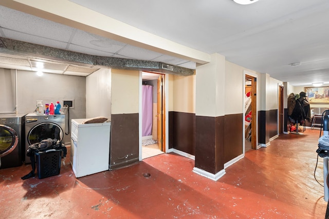 basement with fridge, washer and clothes dryer, and a drop ceiling