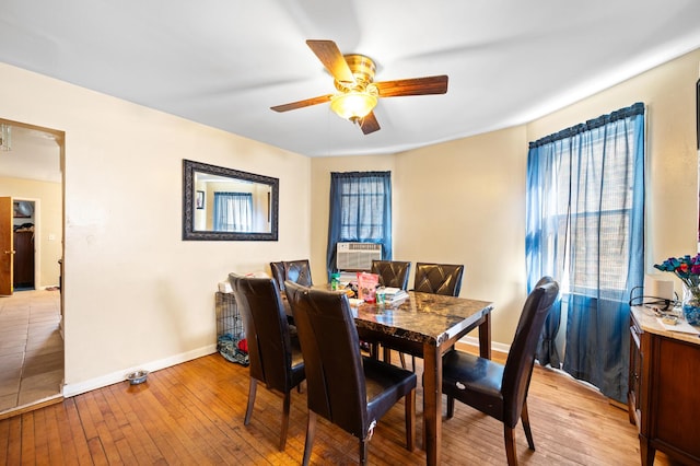 dining room with cooling unit, light hardwood / wood-style floors, and ceiling fan