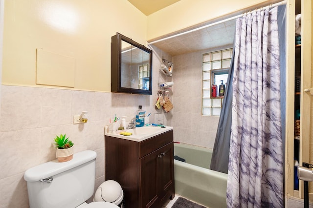 full bathroom with shower / bath combination with curtain, vanity, toilet, and tile walls