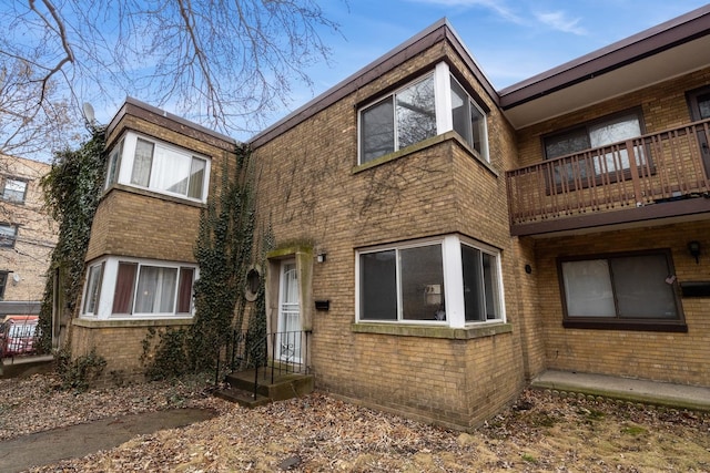 view of front of property with brick siding and a balcony