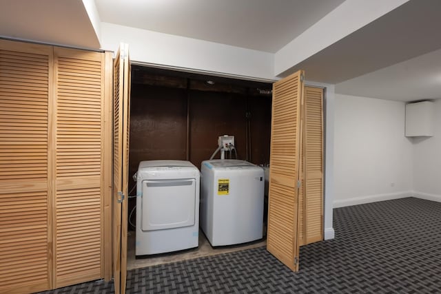 clothes washing area featuring dark colored carpet, laundry area, washing machine and dryer, and baseboards