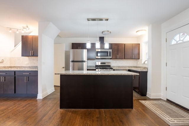 kitchen featuring dark wood-style flooring, decorative light fixtures, appliances with stainless steel finishes, dark brown cabinetry, and a sink