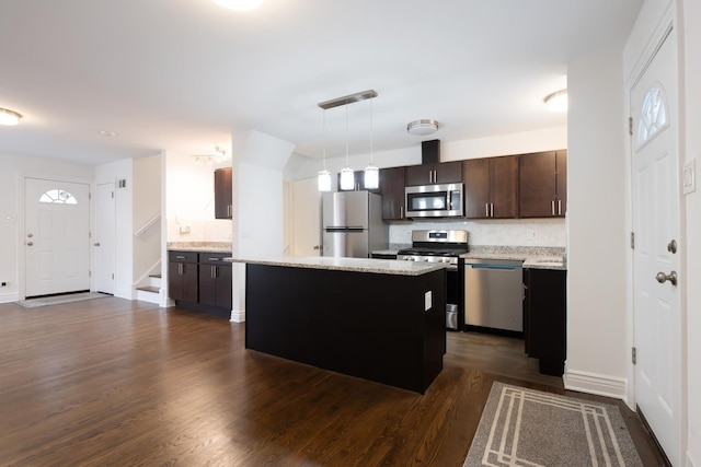 kitchen with appliances with stainless steel finishes, a center island, dark wood-style flooring, and dark brown cabinets