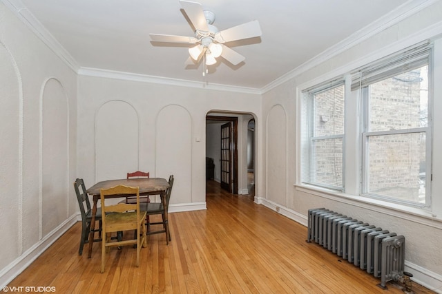 dining room with radiator, crown molding, light hardwood / wood-style floors, and ceiling fan