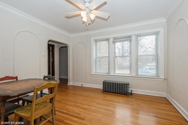 dining area with crown molding, ceiling fan, radiator heating unit, and light hardwood / wood-style floors