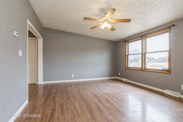 spare room featuring ceiling fan, hardwood / wood-style floors, and a textured ceiling