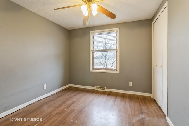 empty room featuring ceiling fan, light hardwood / wood-style flooring, and a textured ceiling